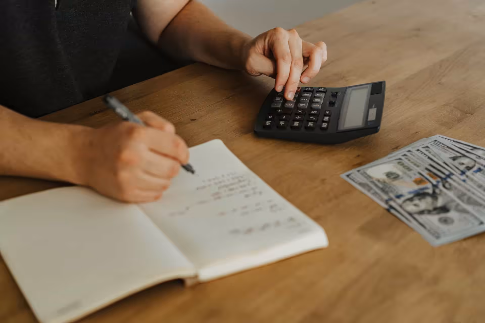 Bills and a calculator spread across a kitchen table