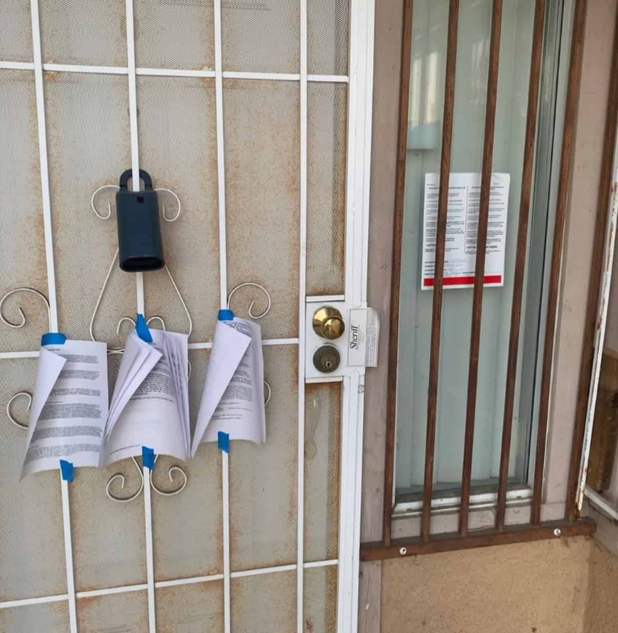 Paper notice taped to the front door of a house